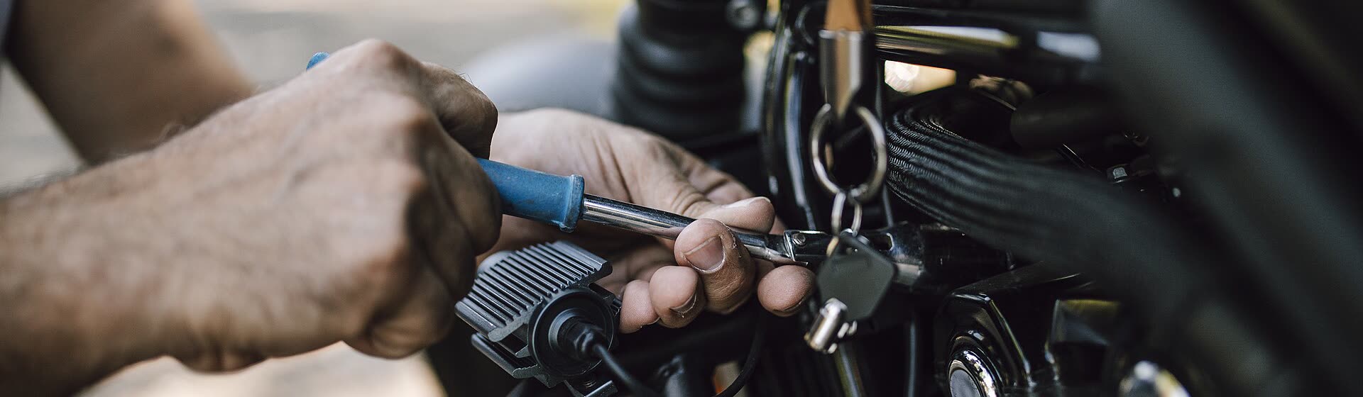 A technician working on a mower deck with a socket wrench